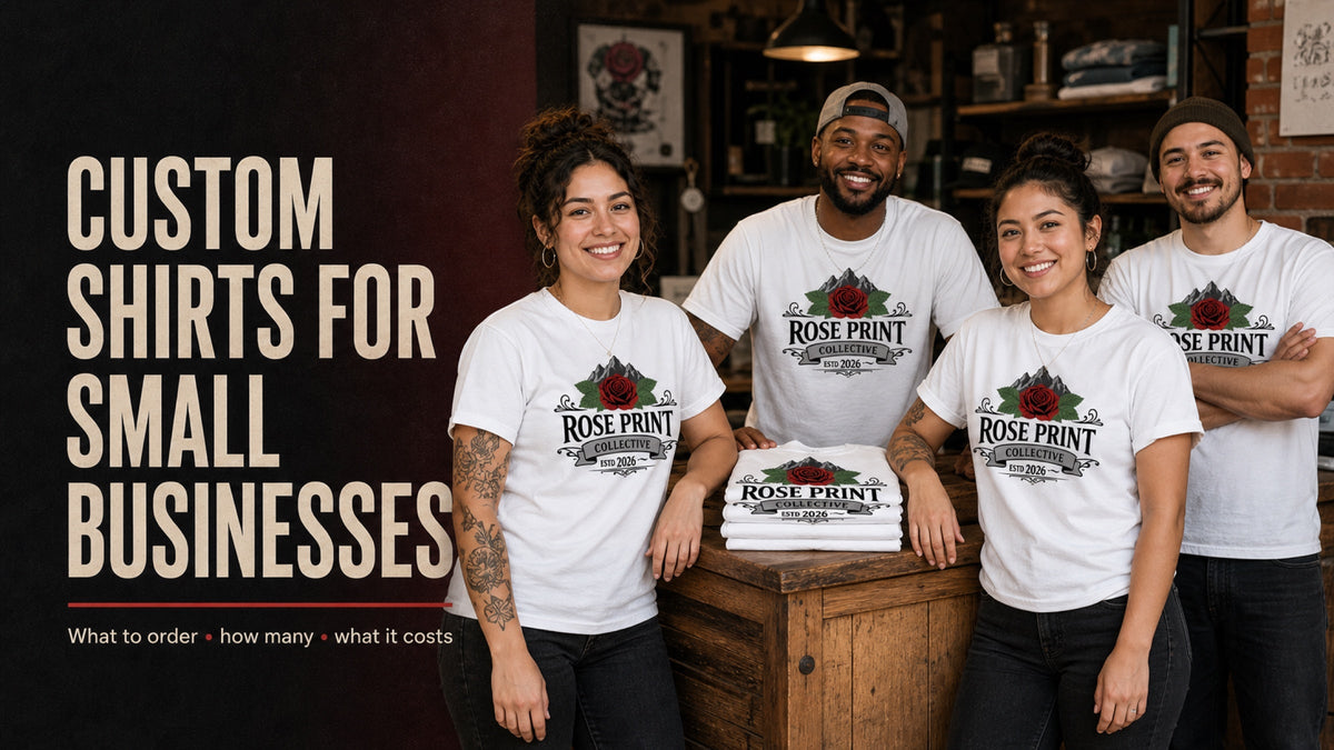 Four-person small-business team in matching white Rose Print Collective logo tees behind a wooden shop counter and stack of folded shirts.