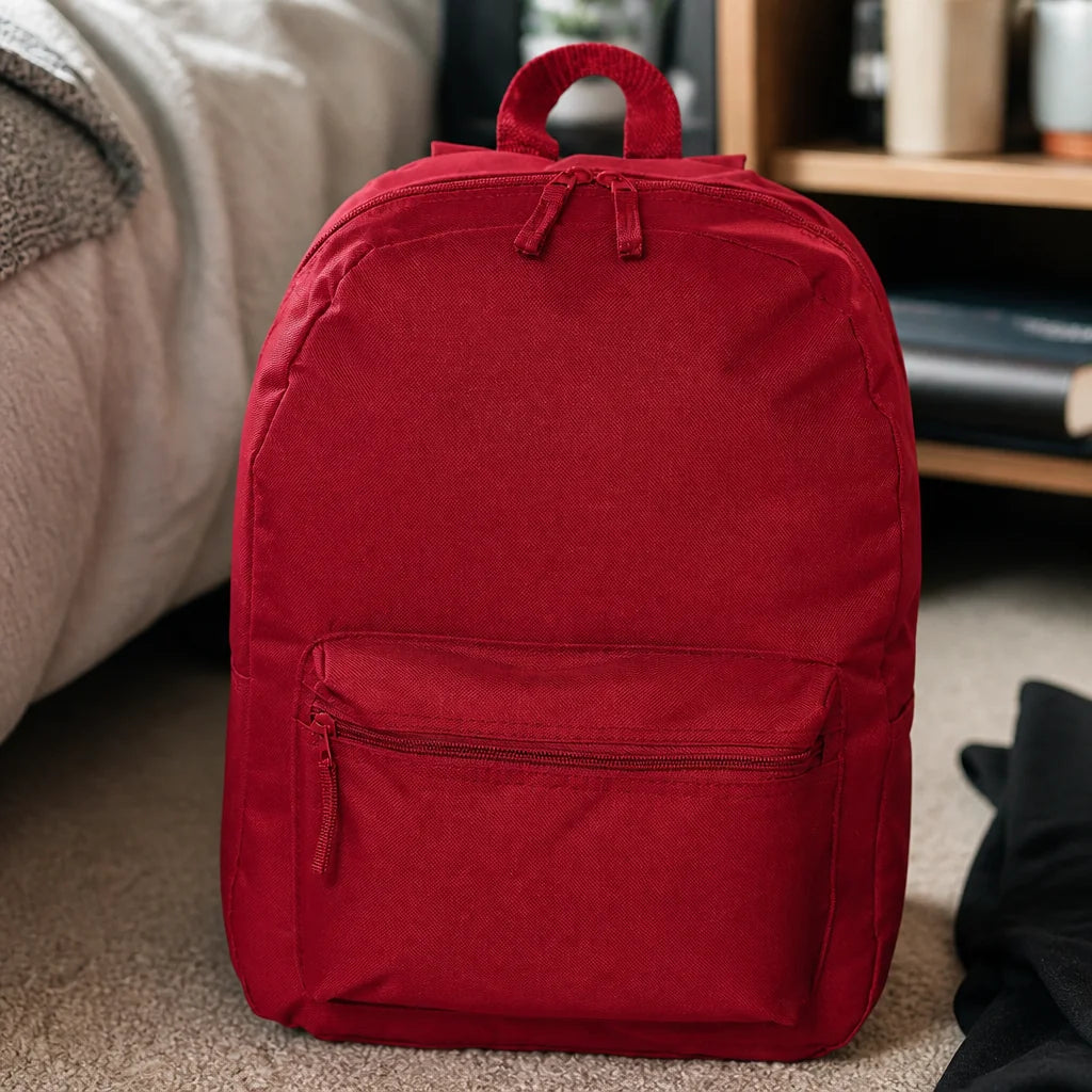 Customizable backpack in red with a top handle and front zippered pocket