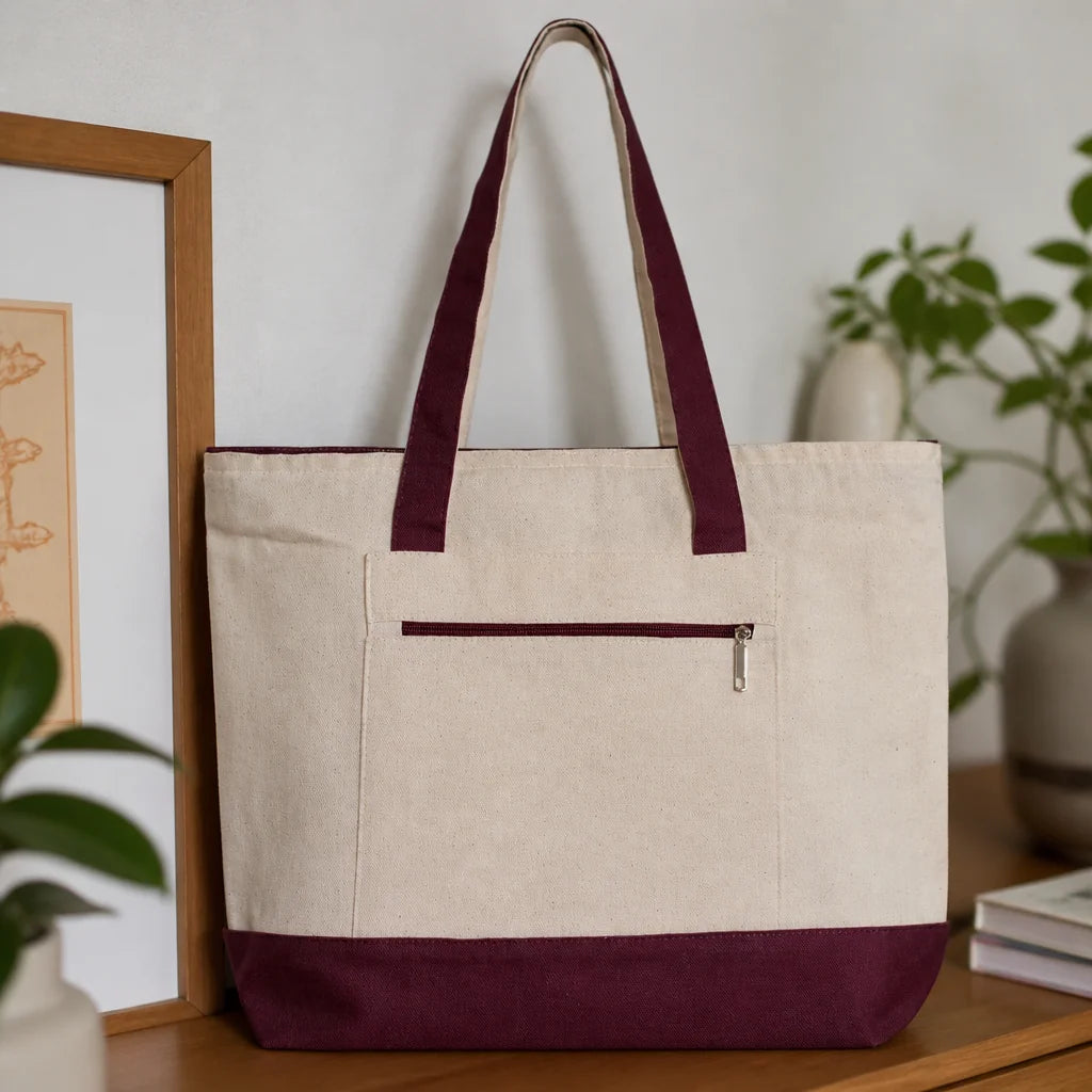Natural canvas tote bag with maroon trim and straps, front zip pocket